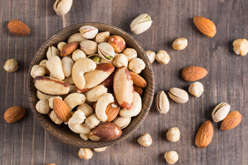Healthy mix nuts on wooden background. Almonds, hazelnuts, cashews, peanuts, pistachios, Brazil nuts
