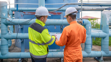 Engineer and technician maintenance checking technical data of system equipment Condenser Water pump and pressure gauge,environmentalist working at water supply