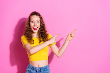 Photo of shiny attractive lady dressed yellow t-shirt pointing two fingers empty space isolated pink color background