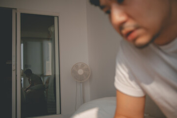 Defocus image depressed lonely asian man looking at mobile phone social media.