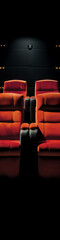 Fototapeta premium Two red plush cinema seats in a dark auditorium with a spotlight