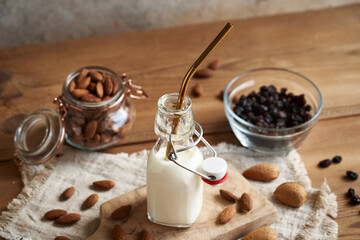 Homemade vegan almond milk in a bottle with a drinking straw made of stainless steel. Zero-waste.