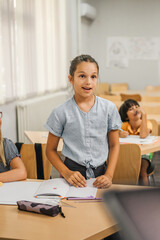 young caucasian girl stand and answer question of teacher