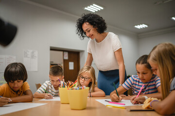 Young students paint and draw on class in the classroom with teacher