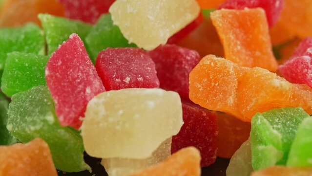 Dried colorful sweet candied fruits mix rotate in macro. Sweets made from dried fruits, kiwi, mango, pineapple, strawberry or gummy candy