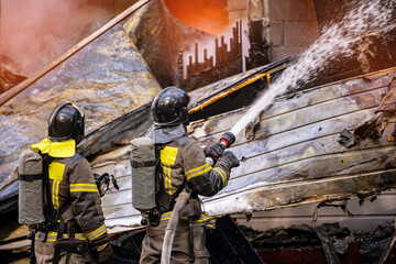 Fire incident in building. Action photo fireman team extinguishes burn with hose water