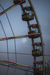 Riesenrad bei Nacht mit Vollmond im Hintergrund