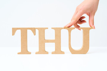 「THU」と並べられたアルファベットの木製ブロック