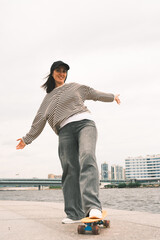 Young sporty woman riding on the skateboard on the road.