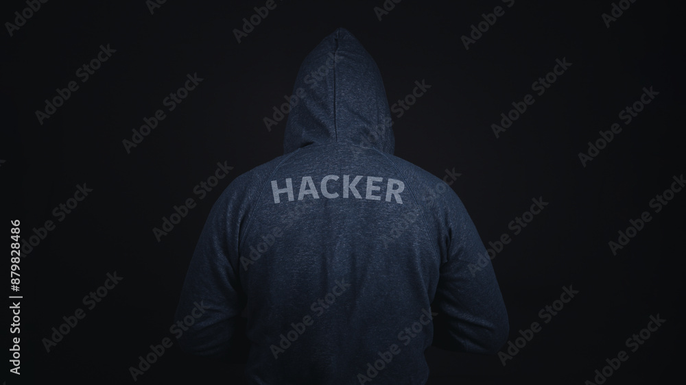 Poster a man is wearing a hoodie with the word hacker on it. the image has a dark mood and a sense of myste