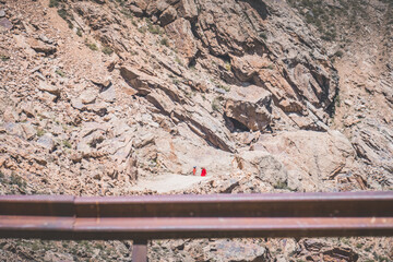 Afghans in bright clothes walk along dusty road in Tien Shan mountains