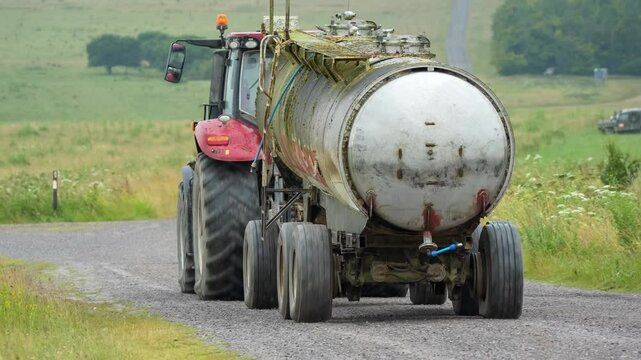 Red Case Puma 340 tractor towing a 30,000 litre water tanker along a stone track