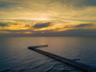 Colorful sunset and Palanga resort pedestrian bridge, pier. Aerial drone photo of summer sunset horizon view over Baltic sea, Lithuania