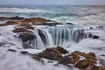 Ocean Sinkhole Cascade over Rocky Ledge Aerial View