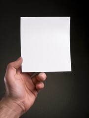 Hand holding a blank white card.