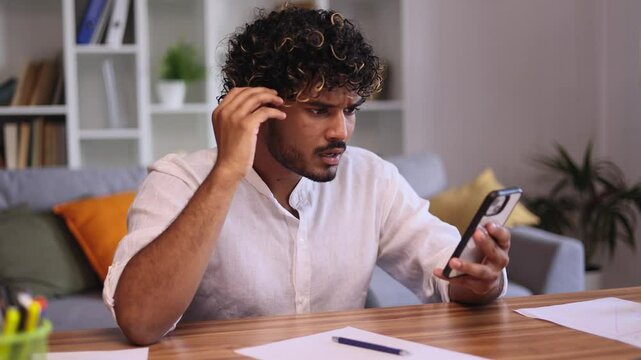 Confused young indian man get notification and feeling upset reading bad negative news message at home workplace indoors Disappointment concept	