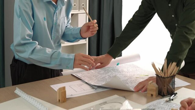 Professional engineer measuring the blueprint. Professional engineer working architectural project at studio on a table with yellow helmet and architectural equipment scatter around. Delineation.