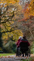 Woman Pushing Wheelchair through Autumn Leaves.