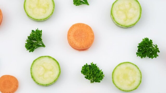 Top view close up of fresh vegetables for cooking isolated on white background in studio. Raw ingredients for vegetable salad, zucchini or marrow, carrot and parsley. Flat lay. Food concept