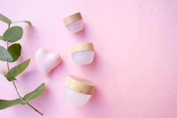 Natural cosmetics concept, cream jars over soft pink background