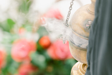 The priest's censer lamp smokes over the grave. Funeral service, memorial service