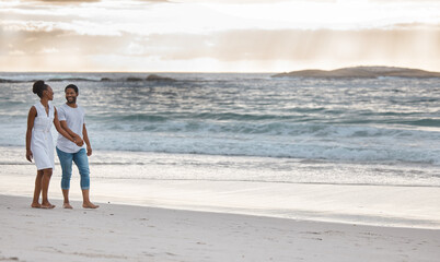 Couple, walking and sunset at beach for holiday, travel and date in summer while bonding together. Man, woman and holding hands by ocean for vacation, love and freedom with romance, water and sand