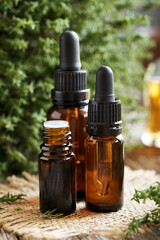 Bottles of aromatherapy essential oil with thyme leaves