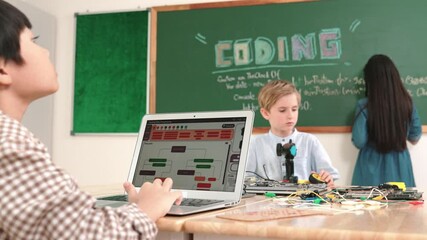 Asian boy coding program while caucasian friend fixing electric board at STEM class. Energetic student standing blackboard while writing coding engineering prompt and programing AI software. Pedagogy.