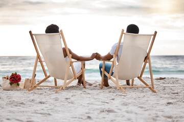 Sunset, black couple and view with beach chair, holding hands or celebrating for anniversary....