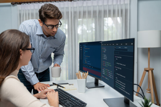 Team skilled developers program thinking newest coding creative website planning software project on two pc screen, comparing with typing full stack data analyzing prompt design at office. Postulate.