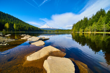 Serene Lake and Rocky Path with Snow-Capped Mountain View