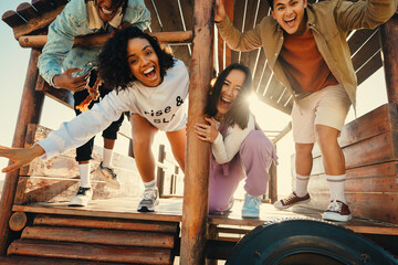 Group of happy friends posing, smiling, and laughing at outdoor wooden playground