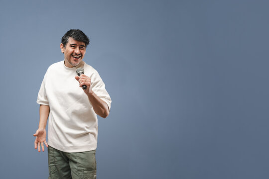 Cantante de karaoke latino sobre fondo gris con espacio negativo para rellenar. Recurso gr&aacute;fico