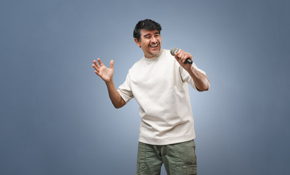 Alegre cantante latino con micr&oacute;fono en la mano. Locutor. Expresiones humanas