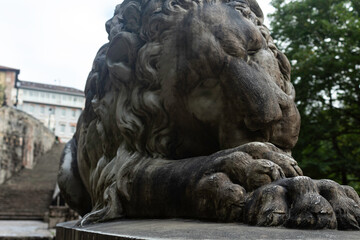 Entrance to the Covadonga cave and hermitage, framed by lush greenery and a lion statue in Asturias, Spain