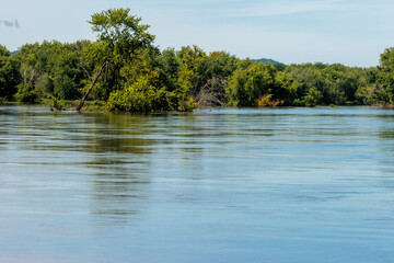 A small island is flooded from the high water of the Wisconsin River as it rushes by from all the...