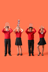 Little classmates in stylish uniform with molecular models on orange background