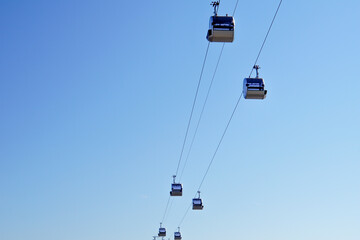 Cabins ride on a cable car against the sky. View from below. Funicular