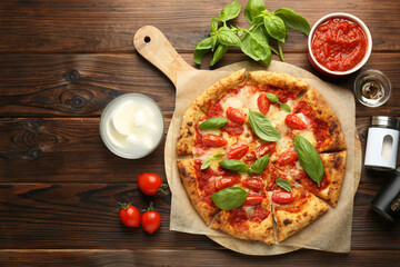 Delicious Margherita pizza and ingredients on wooden table, top view