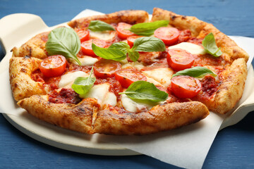 Delicious Margherita pizza on blue wooden table, closeup
