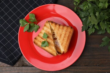 Pieces of toasted bread with melted cheese and parsley on wooden table, flat lay