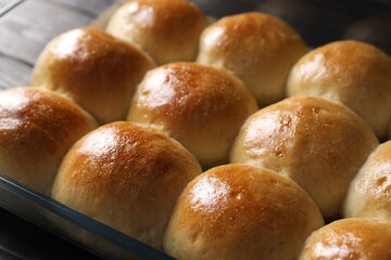 Delicious dough balls in baking dish on table, closeup