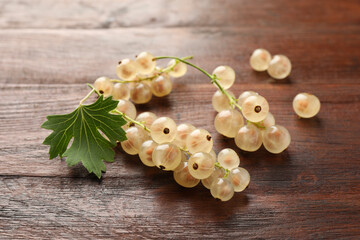 Fresh white currant berries and green leaf on wooden table, closeup