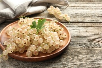 Fresh white currant berries and green leaf on wooden table, closeup