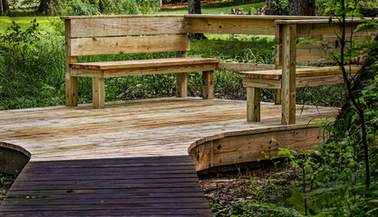 Newly constructed rustic wooden seating, wet after a rainstorm. The platform is a marsh viewing...