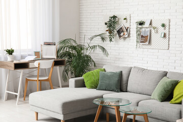 Living room with grey sofa, workplace, coffee table and pegboard