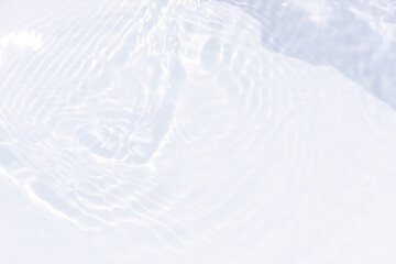 White water with ripples on the surface. Defocus blurred transparent white colored clear calm water surface texture with splashes and bubbles. Water waves with shining pattern texture background.