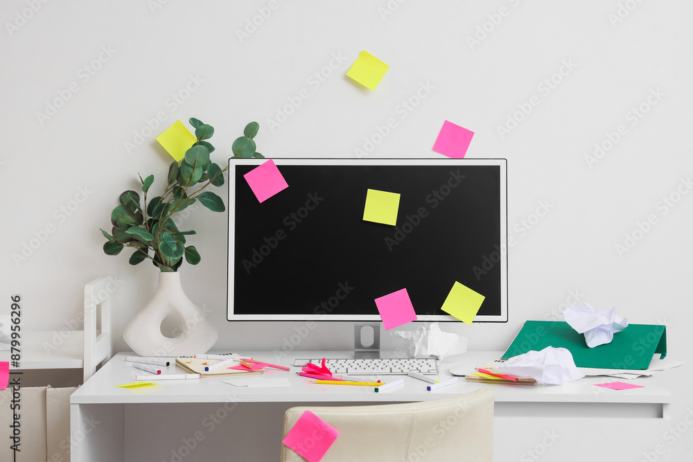 Poster messy workplace with computer monitor and sticky notes in light office