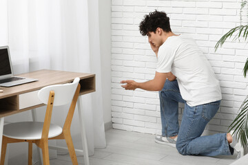 Young man with mold in corner at office