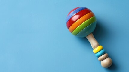 Vibrant baby rattle on a blue backdrop with space for text